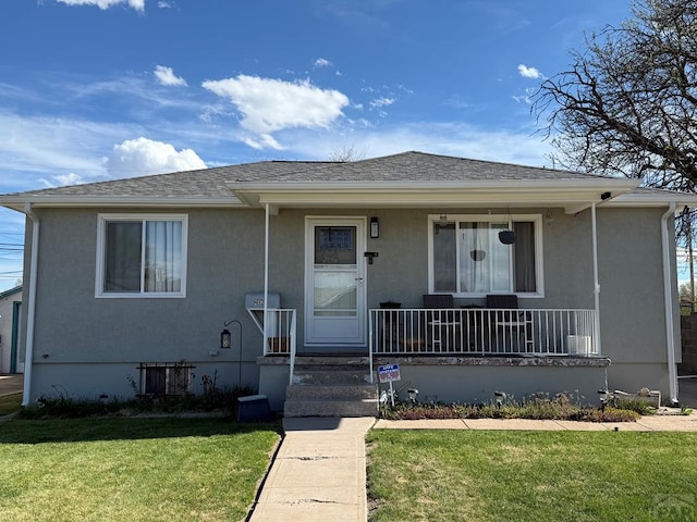 view of front of home featuring a porch, a front yard, and stucco siding