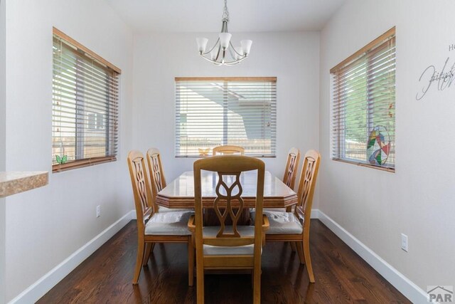 dining room featuring dark wood-type flooring, plenty of natural light, and baseboards