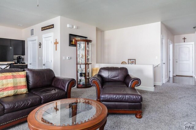 living area featuring carpet floors, visible vents, and baseboards