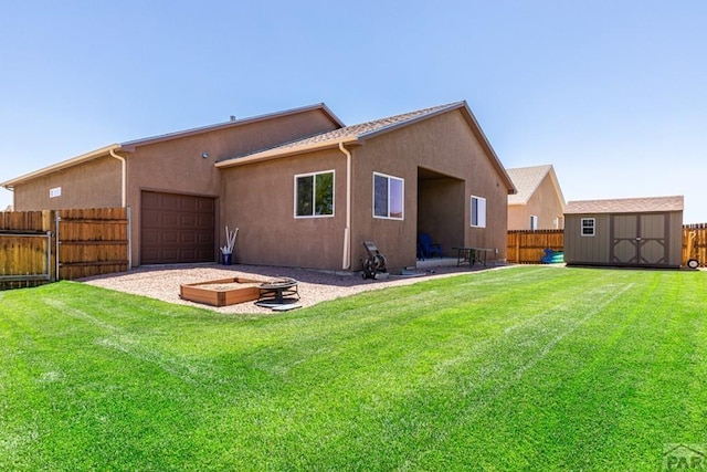 back of house featuring fence private yard, a yard, an outdoor fire pit, and stucco siding