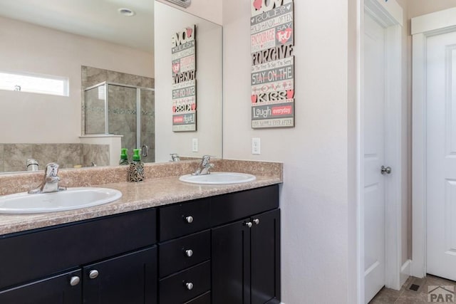 bathroom with double vanity, tile patterned floors, a sink, and a shower stall