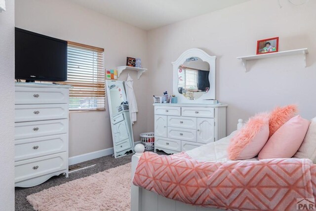 bedroom featuring light carpet and baseboards