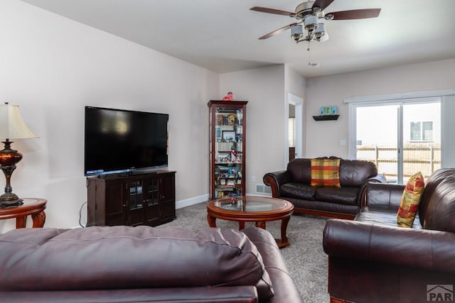 carpeted living area featuring a ceiling fan, visible vents, and baseboards