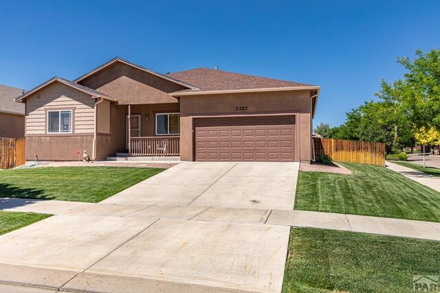 ranch-style home with stucco siding, concrete driveway, fence, a garage, and a front lawn