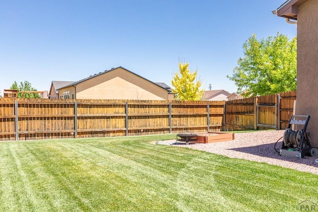 view of yard featuring fence and a fire pit