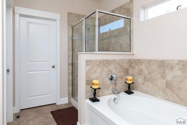 bathroom featuring a garden tub and a shower stall