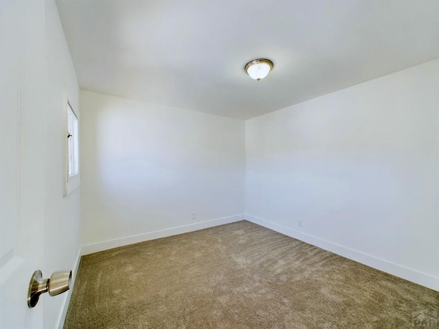 carpeted empty room featuring baseboards