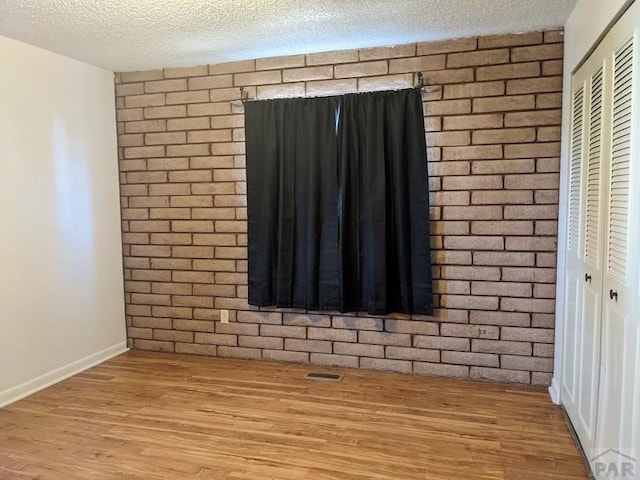 interior details featuring visible vents, a textured ceiling, and wood finished floors