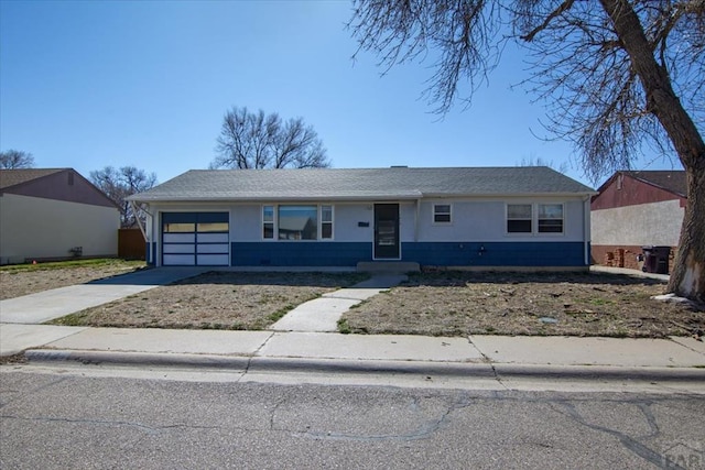 view of front of property featuring concrete driveway, a shingled roof, and an attached garage