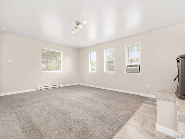 2619 7th Ave, Pueblo, CO 81003 - unfurnished living room featuring a baseboard radiator, baseboards, cooling unit, and wood finished floors