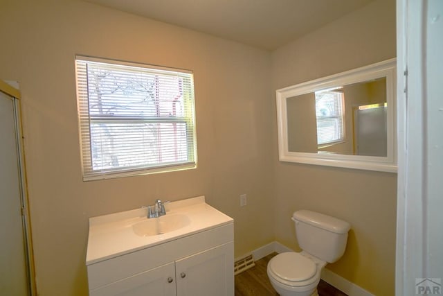 bathroom featuring toilet, vanity, and baseboards