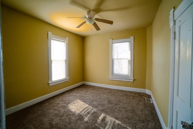 unfurnished room featuring ceiling fan, carpet floors, visible vents, and baseboards