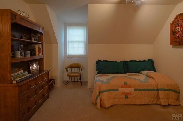 bedroom featuring lofted ceiling and light colored carpet