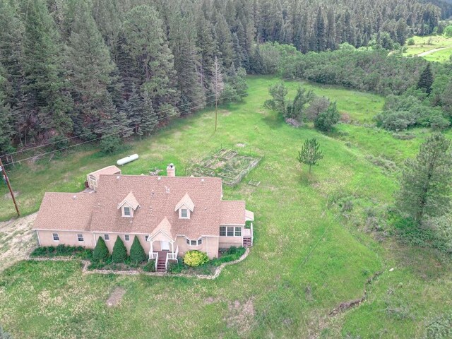 drone / aerial view with a wooded view