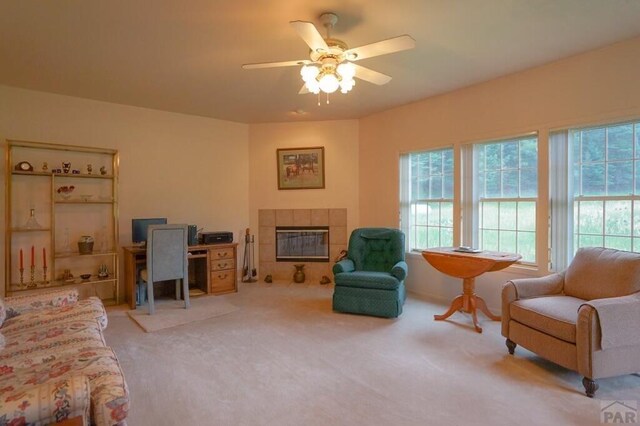 interior space with a fireplace, a ceiling fan, and light colored carpet