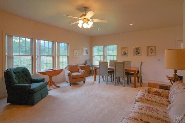 living room with light colored carpet and ceiling fan