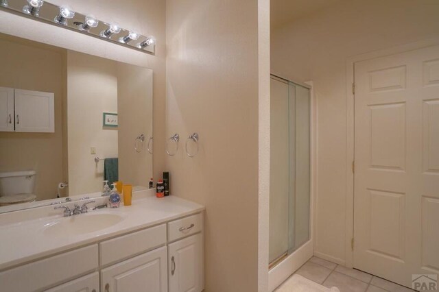 full bathroom with tile patterned flooring, toilet, a shower stall, and vanity