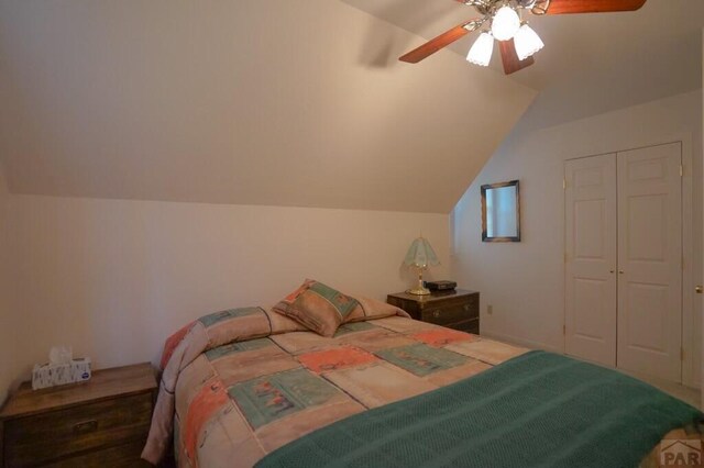 bedroom featuring a closet, vaulted ceiling, and a ceiling fan