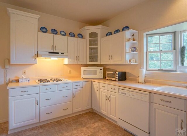 kitchen featuring light countertops, white appliances, white cabinets, and under cabinet range hood