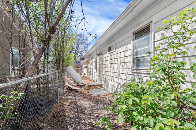 view of side of home featuring fence