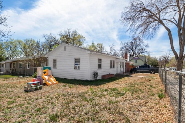 view of side of property featuring a fenced backyard, a playground, and a lawn