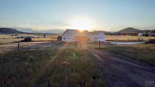 exterior space with a rural view, a mountain view, and dirt driveway