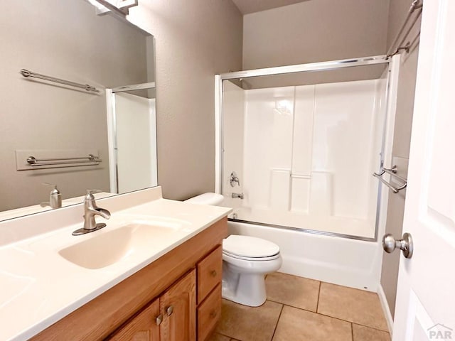 bathroom with toilet, bath / shower combo with glass door, tile patterned flooring, and vanity