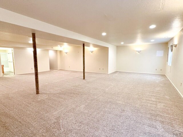 finished basement featuring a textured ceiling, recessed lighting, carpet, and baseboards