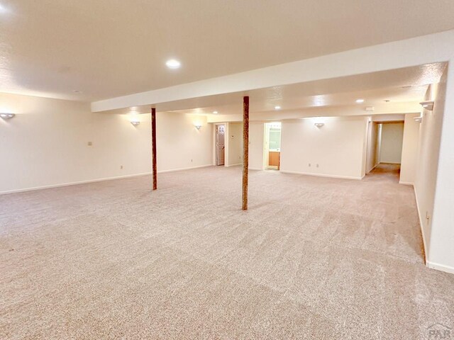 finished below grade area with recessed lighting, baseboards, and light colored carpet