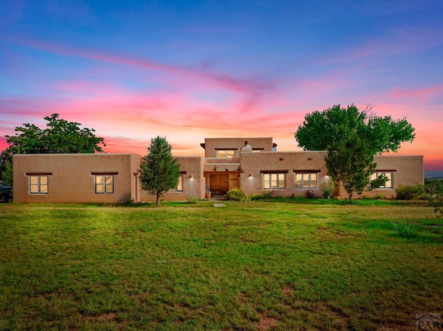 rear view of house featuring a yard