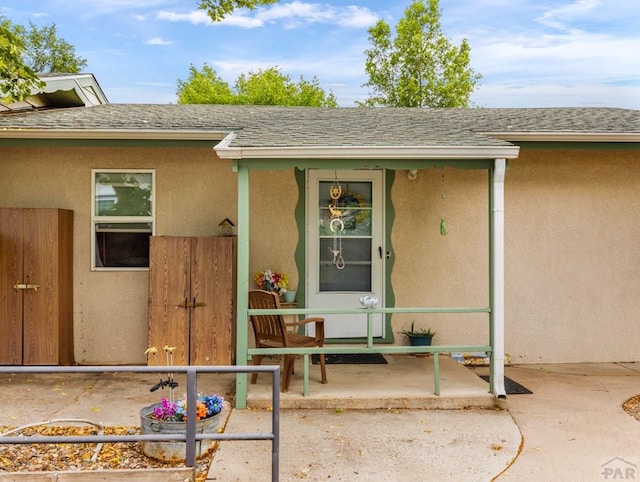 417 Park Dr, Pueblo, CO 81005 - doorway to property with a shingled roof, stucco siding, and a porch