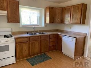 417 Park Dr, Pueblo, CO 81005 - kitchen featuring white appliances, a sink, brown cabinetry, light wood finished floors, and under cabinet range hood