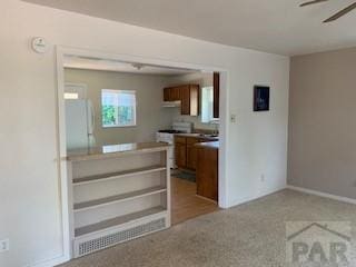 417 Park Dr, Pueblo, CO 81005 - kitchen featuring brown cabinetry, stove, carpet flooring, freestanding refrigerator, and ceiling fan
