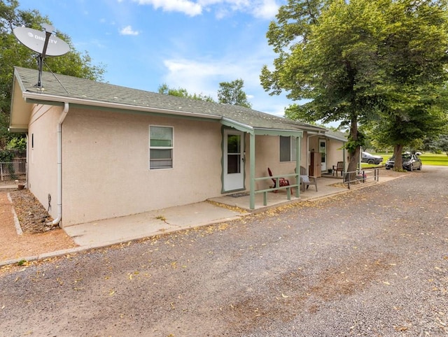 417 Park Dr, Pueblo, CO 81005 - back of house featuring stucco siding, a patio, and roof with shingles