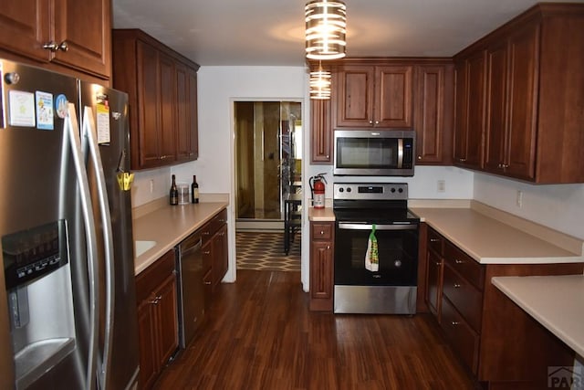 kitchen featuring light countertops, dark wood-style flooring, and appliances with stainless steel finishes