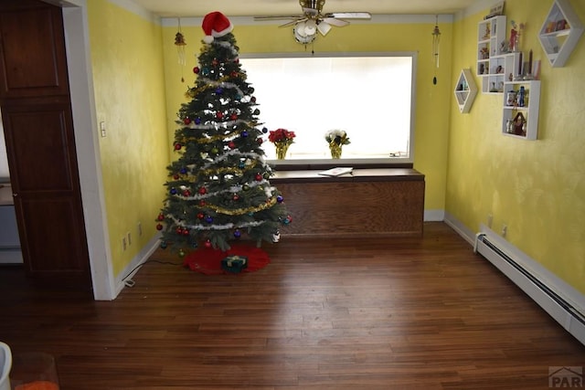 dining area featuring ceiling fan, a baseboard radiator, baseboards, and wood finished floors