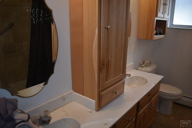 bathroom with vanity, toilet, a tile shower, and a baseboard heating unit