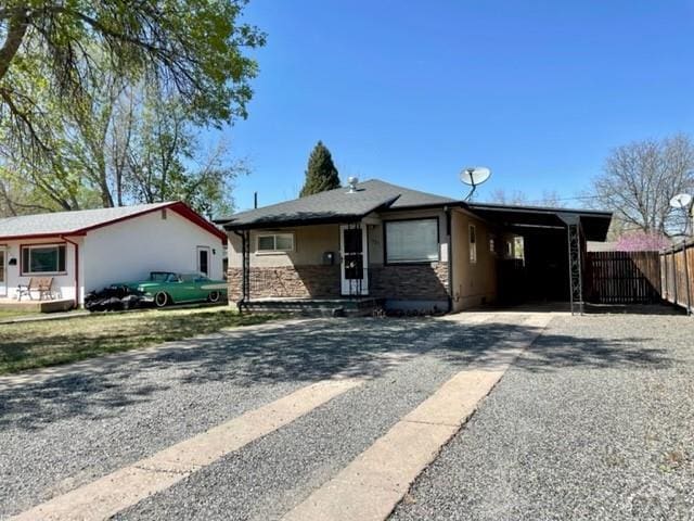 ranch-style home with driveway, a carport, and fence