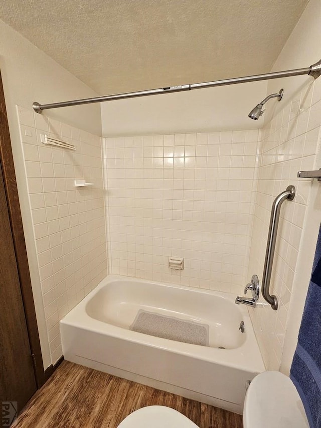 789 W 4th Ave, Springfield, CO 81073 - bathroom featuring toilet, wood finished floors, a textured ceiling, and bathing tub / shower combination