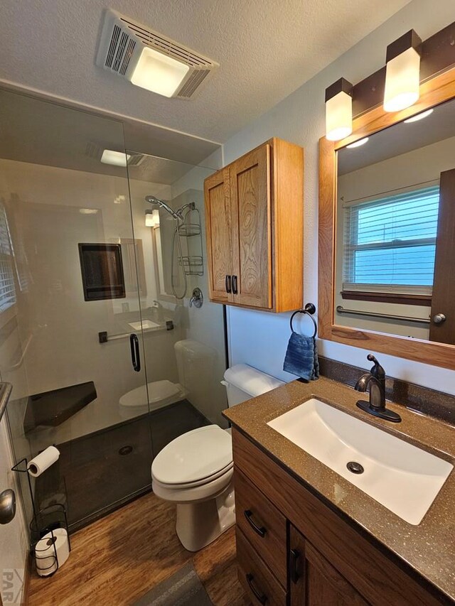 789 W 4th Ave, Springfield, CO 81073 - full bath featuring toilet, vanity, wood finished floors, a shower stall, and a textured ceiling