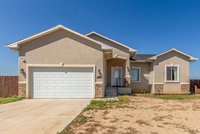 view of front facade featuring stone siding, fence, an attached garage, and stucco siding