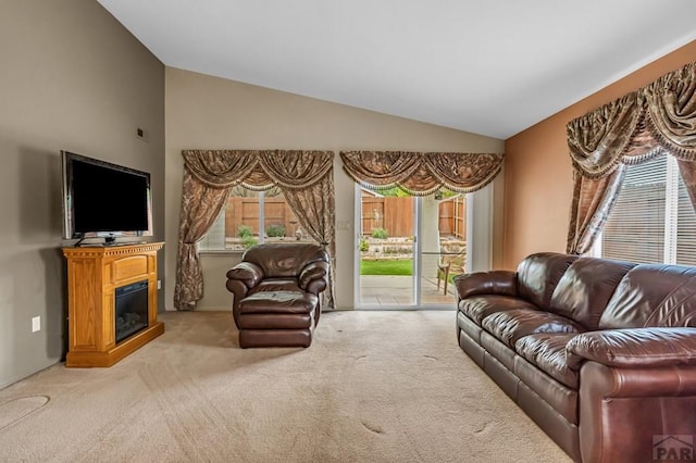 5048 Sage St, Pueblo, CO 81005 - carpeted living room featuring vaulted ceiling and a glass covered fireplace