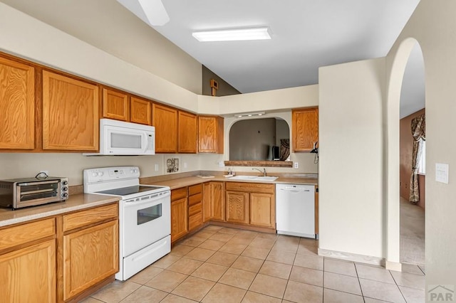 5048 Sage St, Pueblo, CO 81005 - kitchen with white appliances, lofted ceiling, a sink, light countertops, and light tile patterned flooring