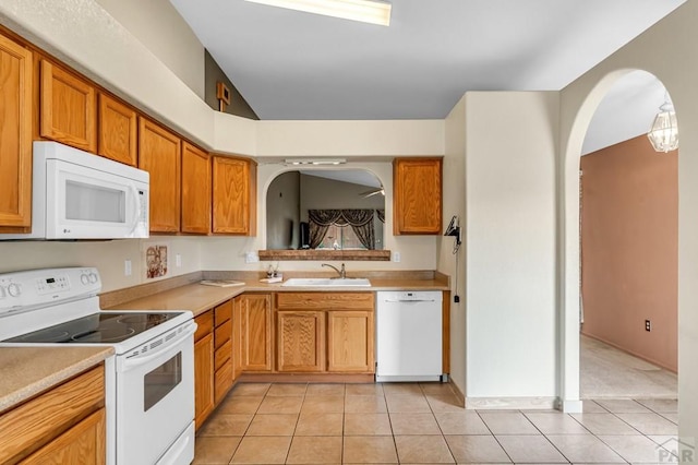 5048 Sage St, Pueblo, CO 81005 - kitchen with white appliances, a sink, light tile patterned floors, light countertops, and vaulted ceiling