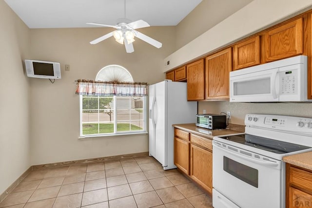 5048 Sage St, Pueblo, CO 81005 - kitchen with white appliances, brown cabinets, a ceiling fan, light countertops, and light tile patterned floors