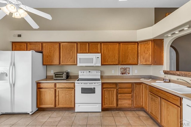 5048 Sage St, Pueblo, CO 81005 - kitchen with white appliances, brown cabinets, light tile patterned floors, and a sink