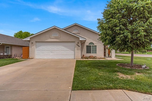 5048 Sage St, Pueblo, CO 81005 - view of front of house with stucco siding, an attached garage, driveway, and a front yard