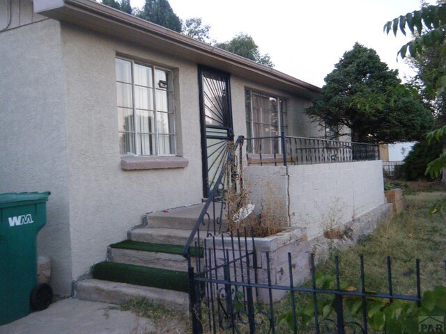 view of front of house with fence and stucco siding