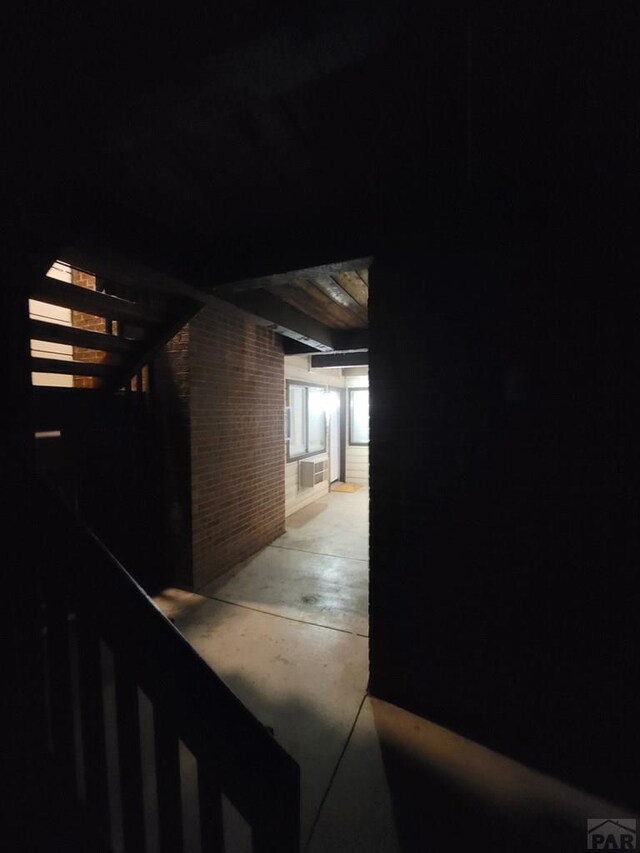 property exterior at night with a patio area and brick siding