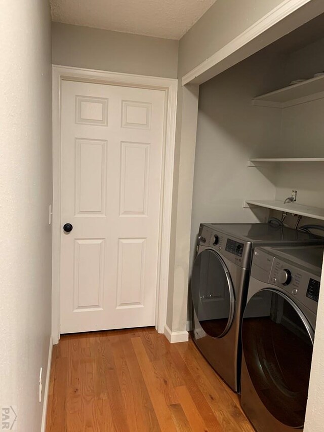 clothes washing area with laundry area, light wood-style flooring, baseboards, and independent washer and dryer